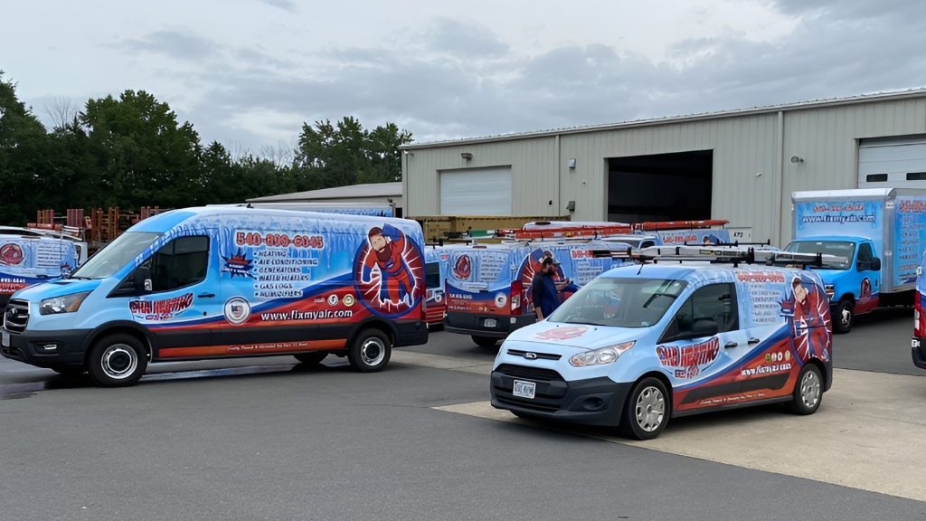 Multiple wrapped vans parked outside a warehouse for a Fredericksburg HVAC company, featuring cohesive red, white, and blue designs created by Core Prints.