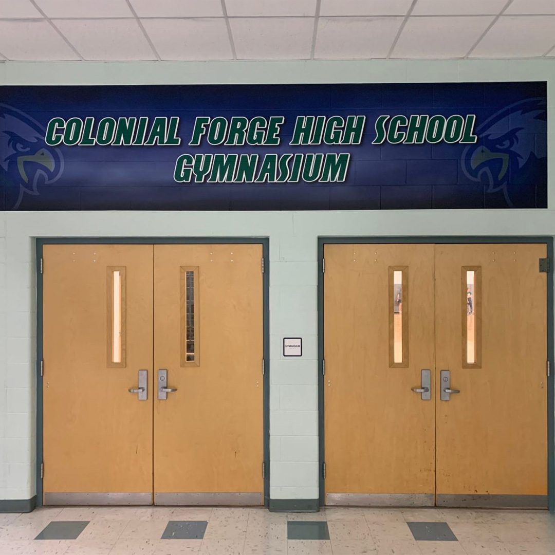 School spirit wall at Colonial Forge with a large branded graphic installed by professional graphic installers to enhance the gym entrance.