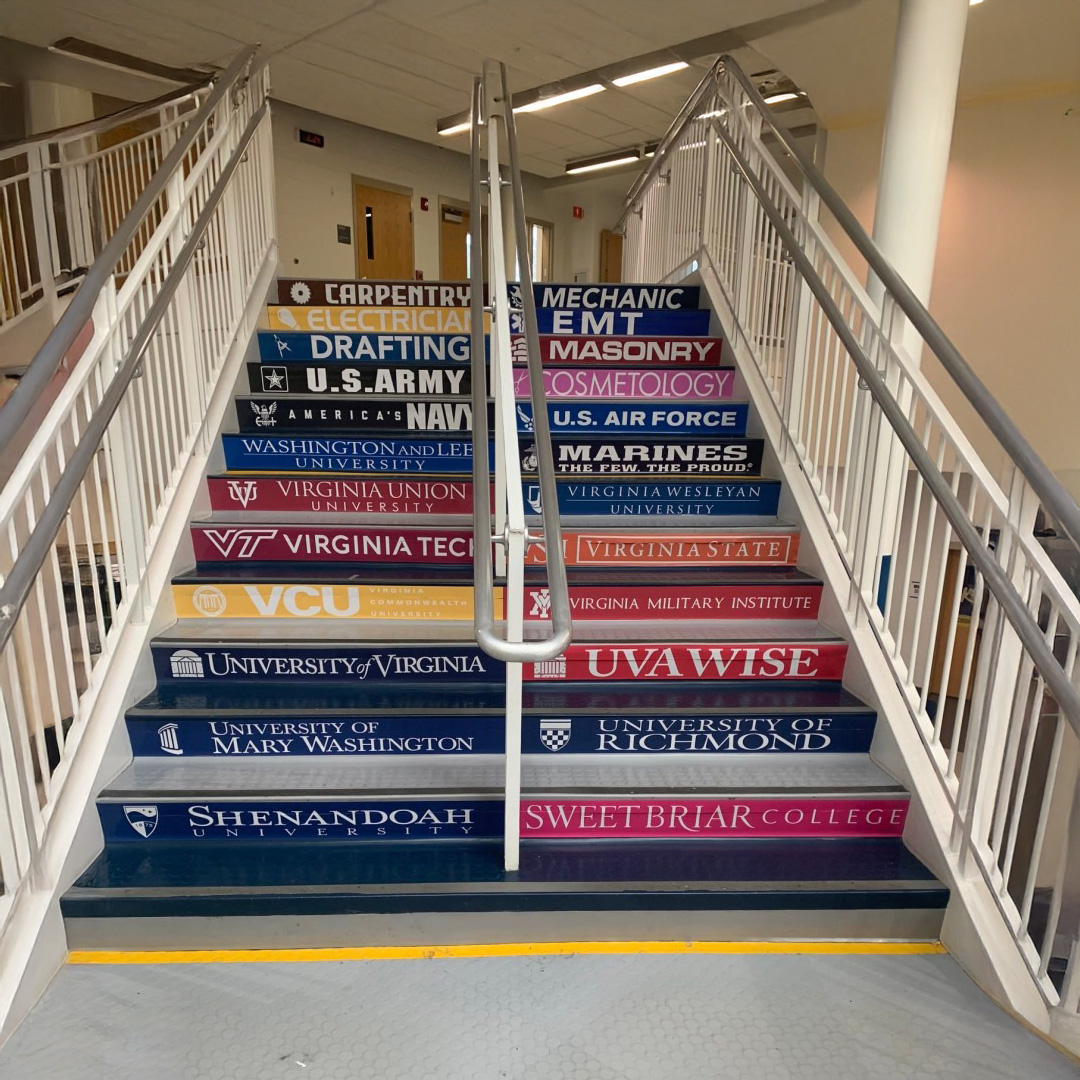 Staircase wrapped in educational and motivational graphics for students, featuring college logos and themed design across all risers.
