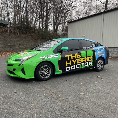 Bright green auto wrap on hybrid service vehicle for The Hybrid Doctor, featuring bold branding, phone number, and service details.